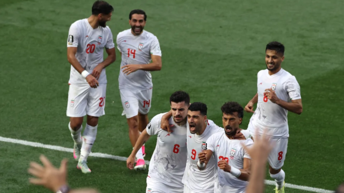 Jogadores da seleção iraniana comemoram em campo durante uma partida de futebol, após eliminação na Copa, quando o tema é “Iraniano processa Fifa” e pede indenização de R$ 5,2 bilhões.