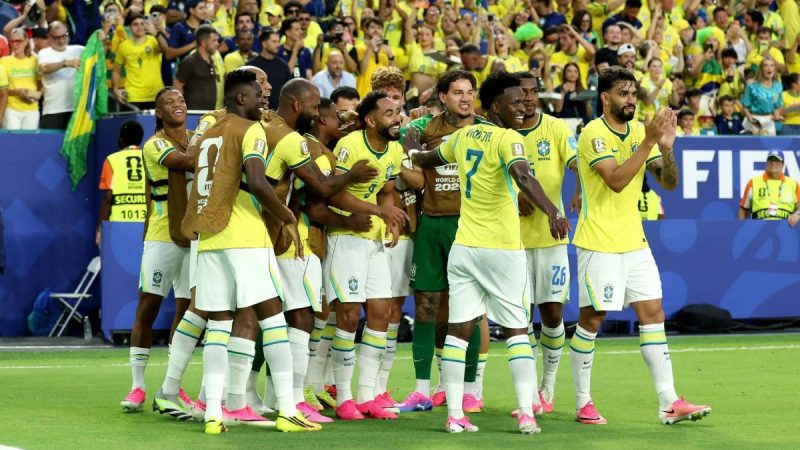 Jogadores da seleção brasileira comemoram em campo durante partida, com muitos torcedores ao fundo. Foto relacionada a lesões no futebol e tempo de recuperação.