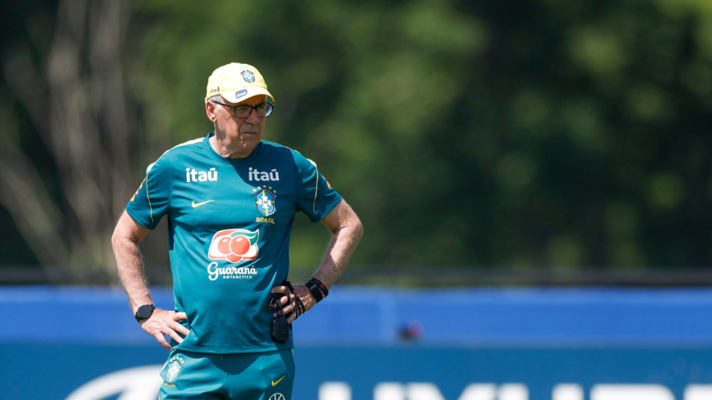 Técnico Ancelotti em treino da seleção brasileira, usando camisa verde e boné, em campo com marcações ao fundo; imagem usada na busca de quem vai substituir Paquetá contra a Noruega com favoritos de Ancelotti.