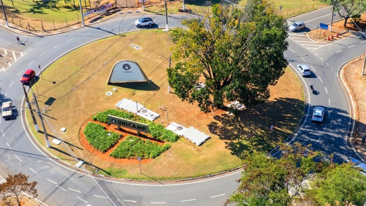 Vista aérea do campus da Unicamp com prédio, área verde e acesso viário, retratando o fim da greve Unicamp e a retomada das atividades na segunda-feira (6), segundo servidores.
