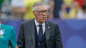 Técnico Carlo Ancelotti durante partida no banco de reservas, com expressão séria, em cenário de jogo decisivo que simboliza a eliminação do Brasil após derrota para a Noruega