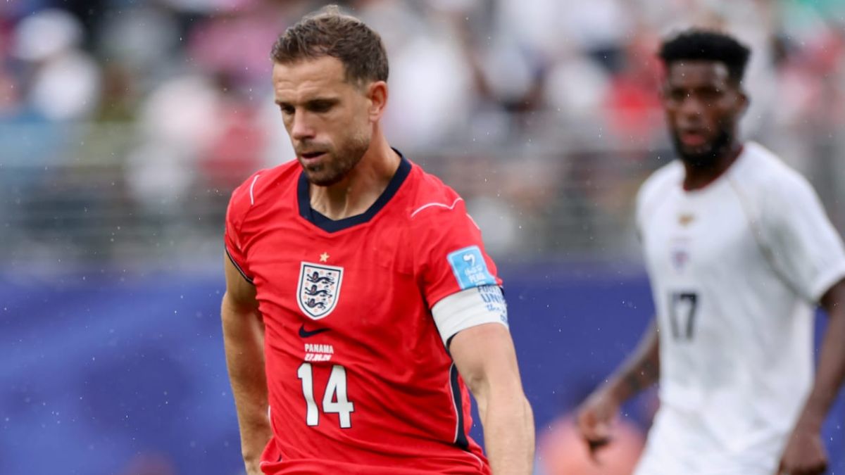 Henderson em partida de futebol, vestindo a camisa vermelha, após um lance de comemoração; ele aparece abatido no gramado, em contexto de Henderson fratura e cirurgia fora da Copa.