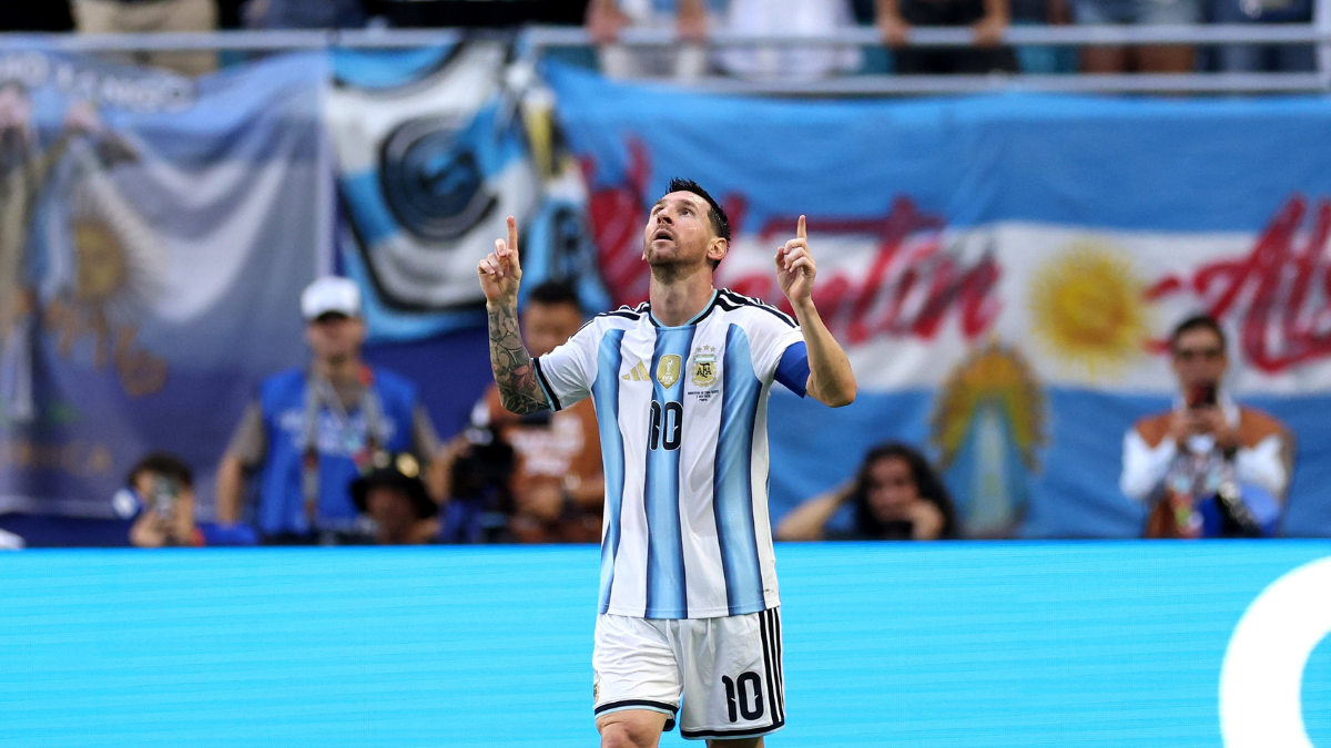 Lionel Messi em campo comemorando durante partida da Argentina na Copa, em destaque com uniforme da seleção argentina, bandeiras e torcida ao fundo, ideal para jogos da Copa hoje e rodada de terça (7).
