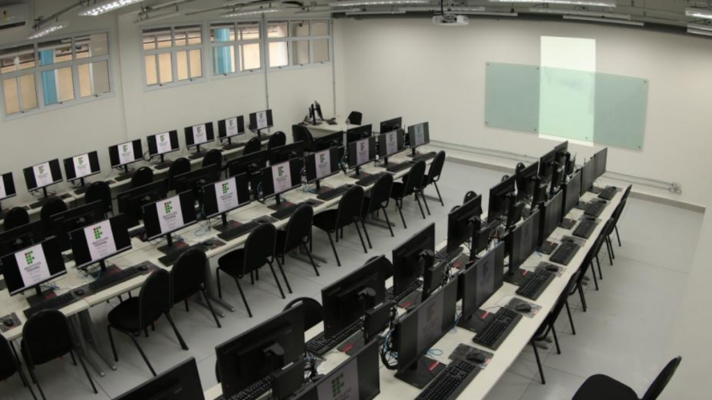 Sala de informática com várias estações de computadores e cadeiras enfileiradas, cenário que representa cursos de qualificação profissional na rede estadual de SP e o recesso escolar da rede estadual de SP.