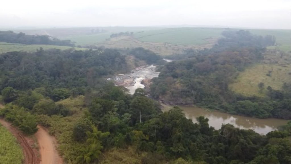 Visão aérea por drone do Rio Jaguari em Cosmópolis, com mata e margens ao fundo, registrada durante a apuração do corpo encontrado no local e a área da perícia.
