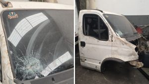 Janela de caminhão com vidro estilhaçado e cabine branca danificada, evidenciando a oficina lacrada em Sumaré após a polícia localizar caminhão roubado.