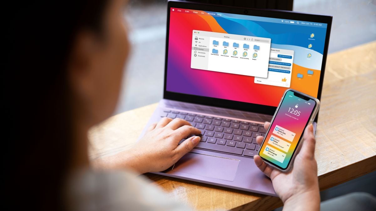 Pessoa usando notebook e smartphone, com a tela exibindo aplicativos, enquanto navega na internet. Ilustra tempo online no Brasil e o uso diário das redes.