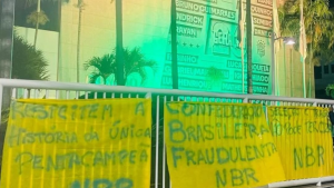 Sede CBF Brasil com faixas e cartazes amarelos em protesto na frente da instituição, com mensagens críticas após eliminação do Brasil na Copa.