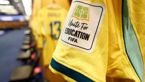 Roupa de uniforme esportivo com camisa amarela e etiqueta FIFA “White for Education”, imagem que ajuda a explicar por que não tem Copa do Mundo hoje.