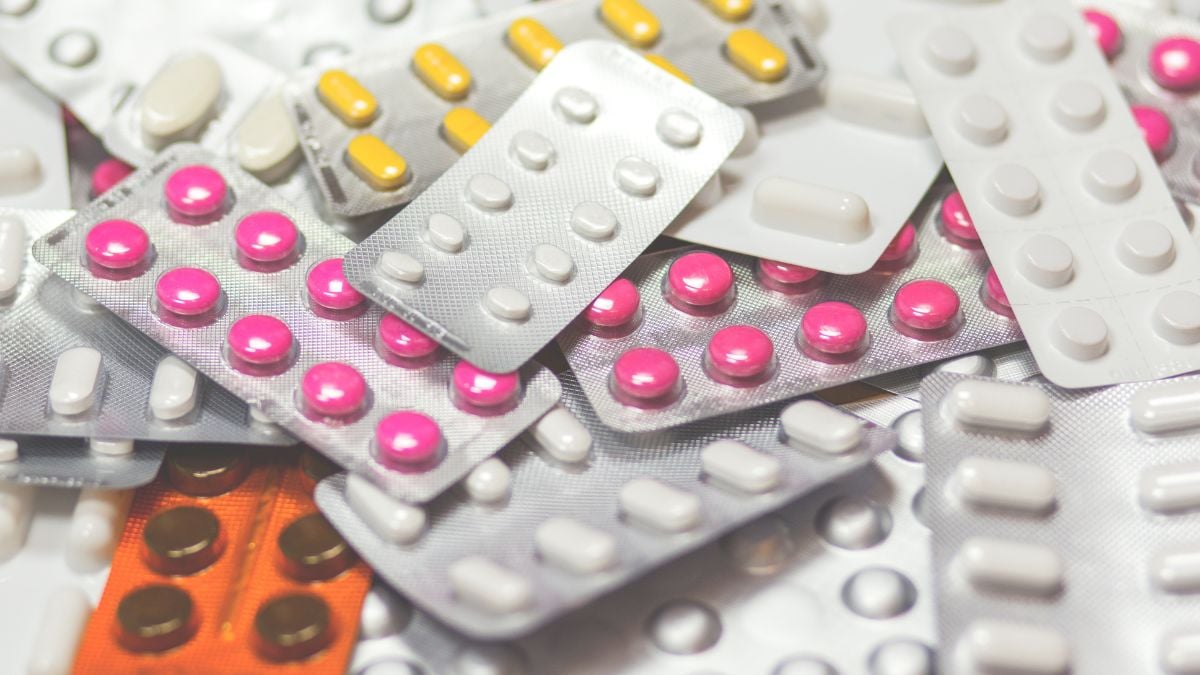 Cartela com comprimidos e medicamentos variados, com caixas de blísteres sobrepostas, reforçando a ideia de preços de medicamentos que podem variar muito entre farmácias de SP.