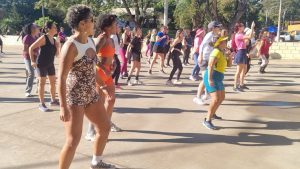Pessoas participam de atividade gratuita de ritmos ao ar livre na Lagoa do Taquaral, em meio a uma caminhada coletiva, roupas coloridas e clima de domingo ensolarado.