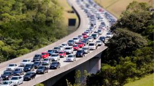 Congestionamento na rodovia com veículos em ambas as faixas, visto de cima, ilustrando a Operação Subida 2x8 em vigor no Sistema Anchieta-Imigrantes.