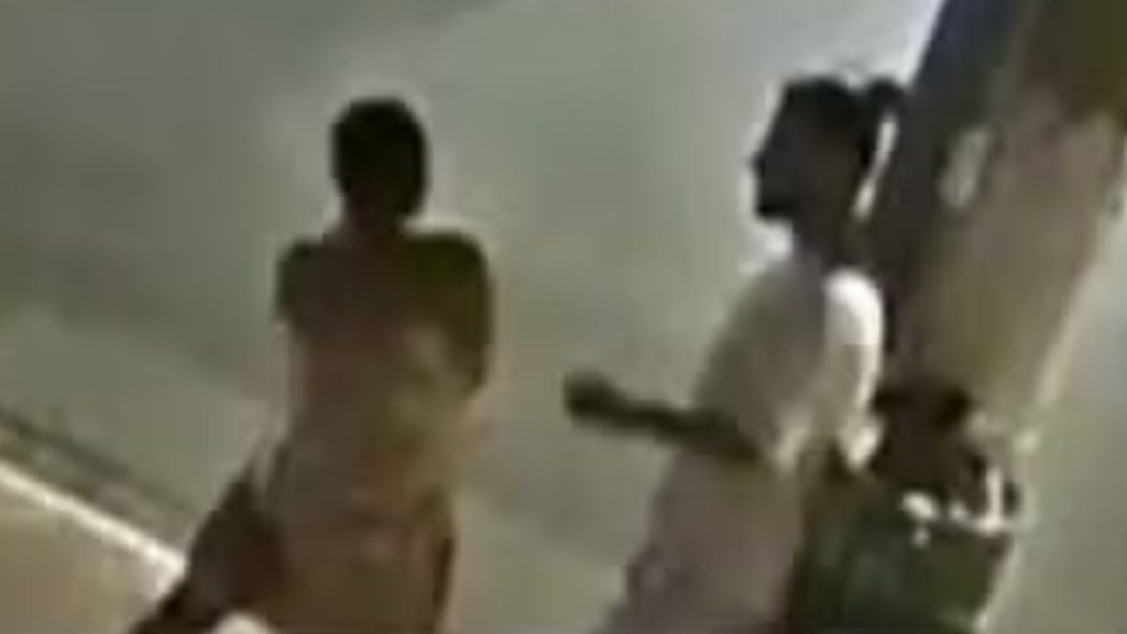 Cartolouco em imagem de câmeras de segurança durante uma discussão, encostando um cigarro aceso na orelha da namorada; frame desfocado (Reprodução/TV Globo).