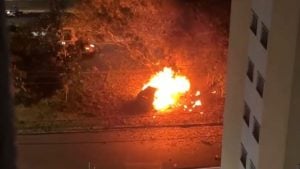 Porsche em chamas em Campinas após uma batida, com fogo intenso e chamas altas visíveis na rua à noite, em meio a veículos ao fundo.