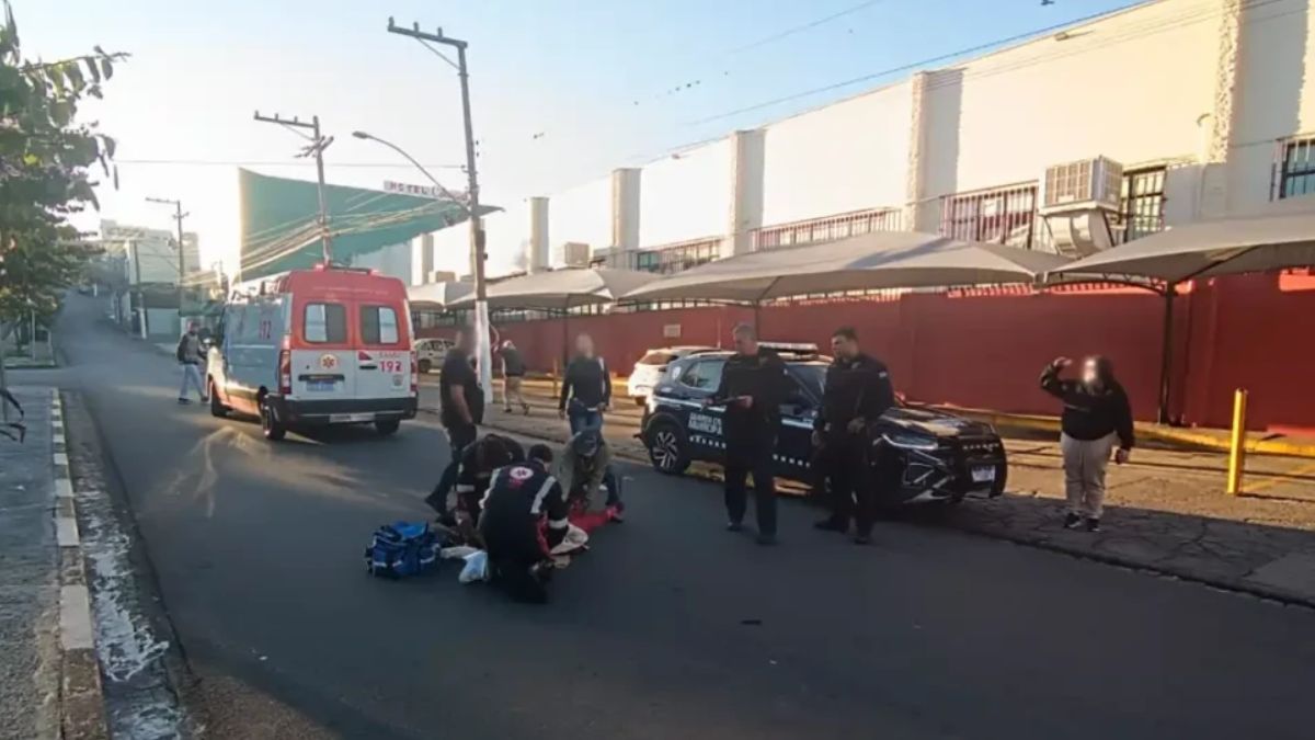 Cena de acidente em via urbana de Bragança Paulista: equipes e viaturas estão no local após uma idosa ser atropelada por motociclista que fugiu, com objetos na pista.
