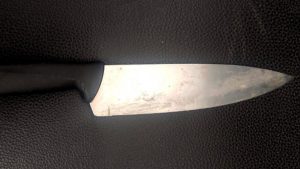 Faca com lâmina metálica em close, usada em briga e agressões; contexto de prisão de mãe e filha em Charqueada após incidente com faca.