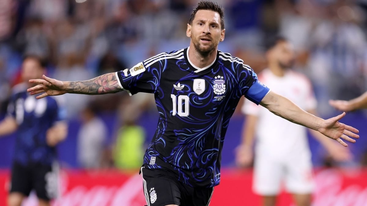 Argentina em partida de futebol: Lionel Messi com a camisa azul e preta da seleção argentina, número 10, fazendo gesto com os braços abertos no estádio, em clima de semifinal contra a Inglaterra.