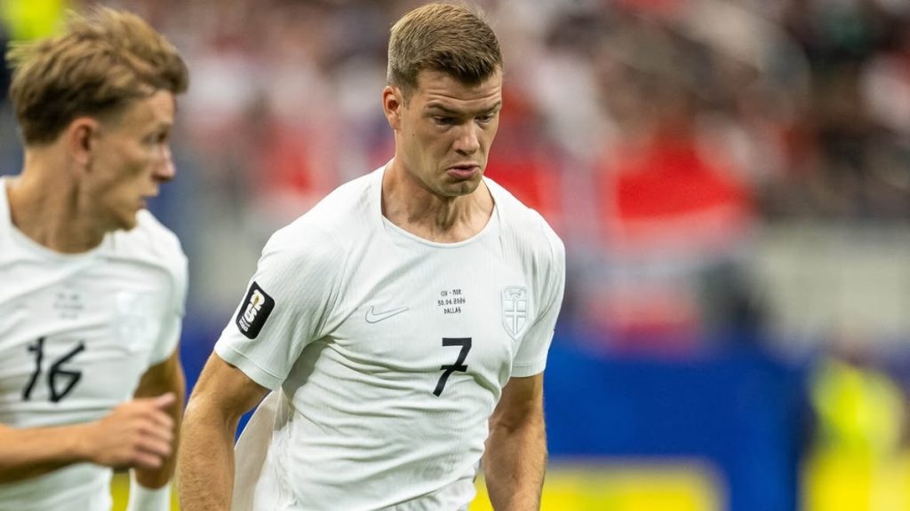 Sorloth em campo, com expressão séria, durante partida da Noruega contra a Inglaterra; ele recebe ameaças após a eliminação na Copa.