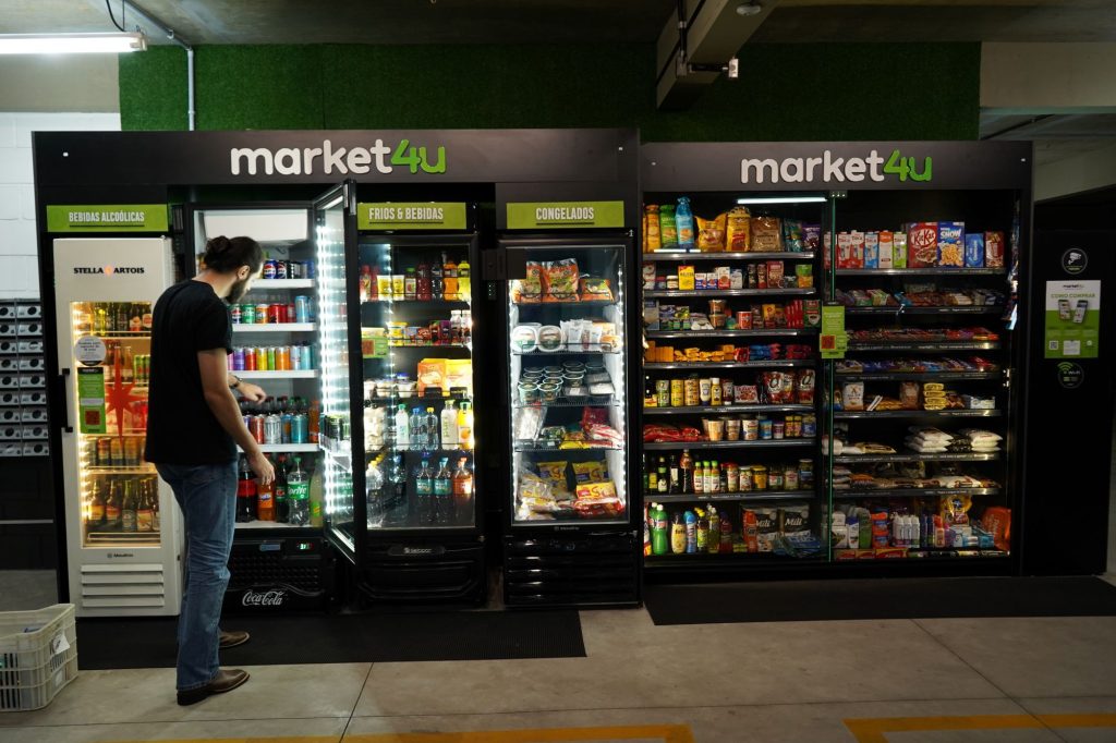 Prateleiras e freezers de um mercado Market4u com bebidas e snacks em destaque, cenário de vendas na Copa do Mundo mesmo sem o Brasil em campo.