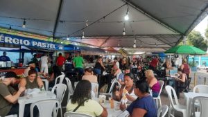 Varejão Municipal da Paulista em Piracicaba, com área de alimentação coberta e mesas ocupadas por pessoas em barracas de comida durante o dia.