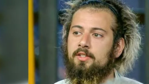 Cartolouco em foto de perfil, com cabelo comprido e barba, em destaque no noticiário. Cartolouco se torna réu após a Justiça aceitar denúncia por violência doméstica.