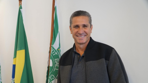Jorginho sorri em foto ao lado de bandeiras do Brasil e de um clube, em entrevista ou declaração após críticas a jogadores do Brasil na sequência da Copa. Tetracampeão detona postura: “Parece que nada aconteceu”.