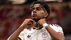 Lamine Yamal em campo usando camisa da seleção da Espanha, em imagem de arquivo desfocada ao fundo, destacando o jogador em contexto de notícia sobre tentativa de invasão na casa do atleta na Espanha.