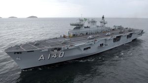 Imagem do maior navio de guerra da América Latina, navio militar A 140, em mar aberto próximo ao Porto de Santos, com convés e parte da ponte visíveis.