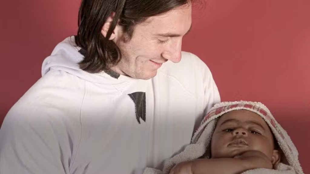 Messi x Lamine Yamal: imagem mostra Lionel Messi ao lado de uma criança em ambiente interno, com Messi sorrindo e demonstrando carinho, destacando o contraste de gerações na final da Copa.
