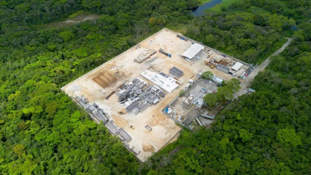 Vista aérea de uma estação de tratamento da Sabesp em Praia Grande, com estruturas industriais e áreas cercadas por mata, na Baixada Santista. Foto de reprodução.