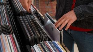 Feira de Vinil em Campinas: mãos escolhendo discos de vinil em uma banca com várias capas alinhadas, em um evento realizado em shopping da cidade.