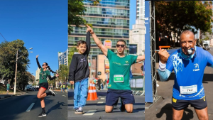 Corredores em plena pista durante a Maratona de Campinas, com participantes cruzando a linha em clima de comemoração, ao fundo prédios e cones de sinalização viária.
