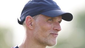 Thomas Tuchel, técnico de futebol, aparece em close usando boné azul e expressão concentrada durante partida ao ar livre