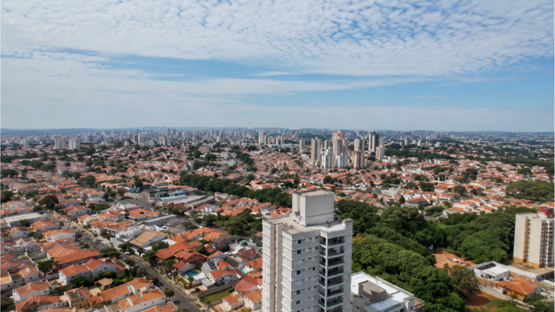 Panorama de Campinas visto do alto com prédios e áreas verdes, destacando anúncio de vagas de emprego em Campinas e Paulínia nos setores químico e do agronegócio.