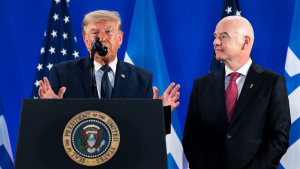 Trump quer outra Copa do Mundo nos Estados Unidos: Donald Trump fala ao lado de Gianni Infantino, presidente da Fifa, em evento oficial, com bandeiras dos EUA ao fundo.