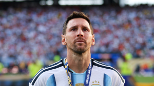 Messi durante partida da Argentina, com expressão emotiva e olhar para a torcida no estádio após a derrota na Copa do Mundo. O craque parece segurar as lágrimas.