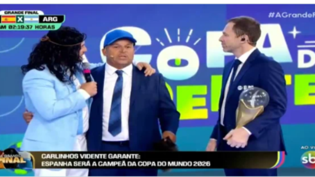 Carlinhos Vidente em entrevista ao lado de apresentadores em estúdio, em cena sobre previsão de que o Brasil pode trazer a Copa para casa em 2030, crédito SBT.
