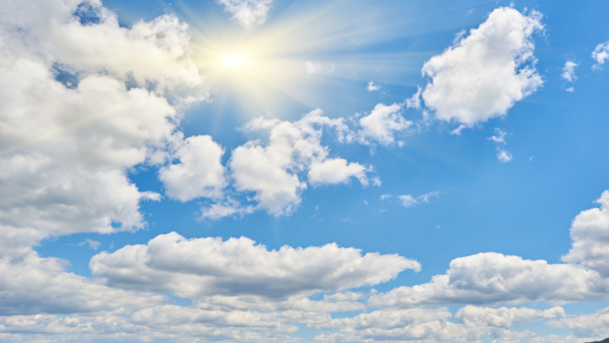 Céu azul com nuvens brancas e tempo firme, sugerindo tempo em São Paulo no início de agosto segundo previsão meteorológica.