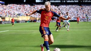 Jogador de futebol em campo com a bola nos pés, em partida com arquibancada lotada, em cena que remete à votação gol mais bonito da Copa de 2026 promovida pela FIFA