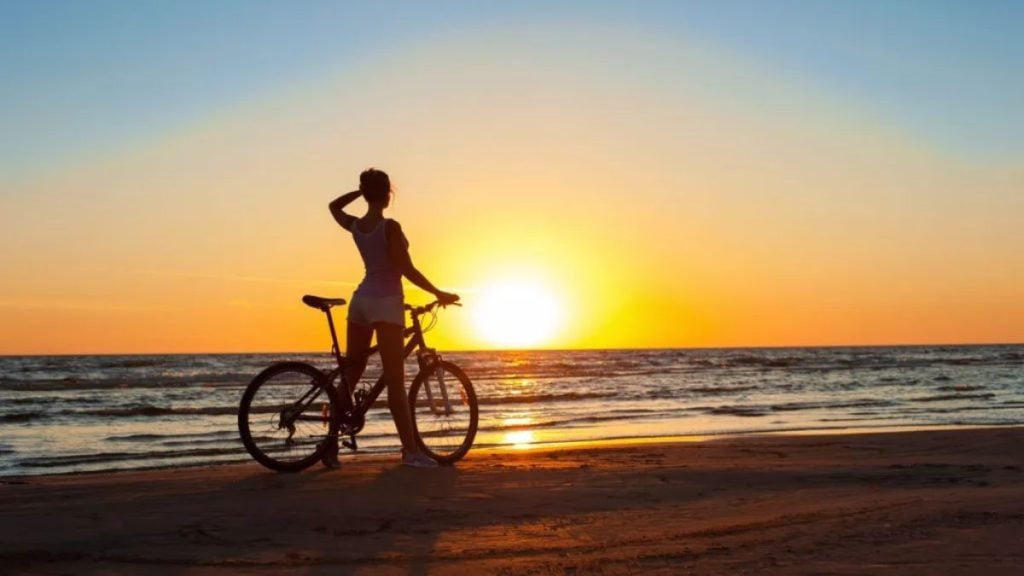 Pessoa pedalando na areia da praia