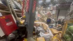 Desabamento atacadão em estoque com prateleiras e mercadorias destruídas no interior da loja, no litoral de São Paulo, com área interditada.