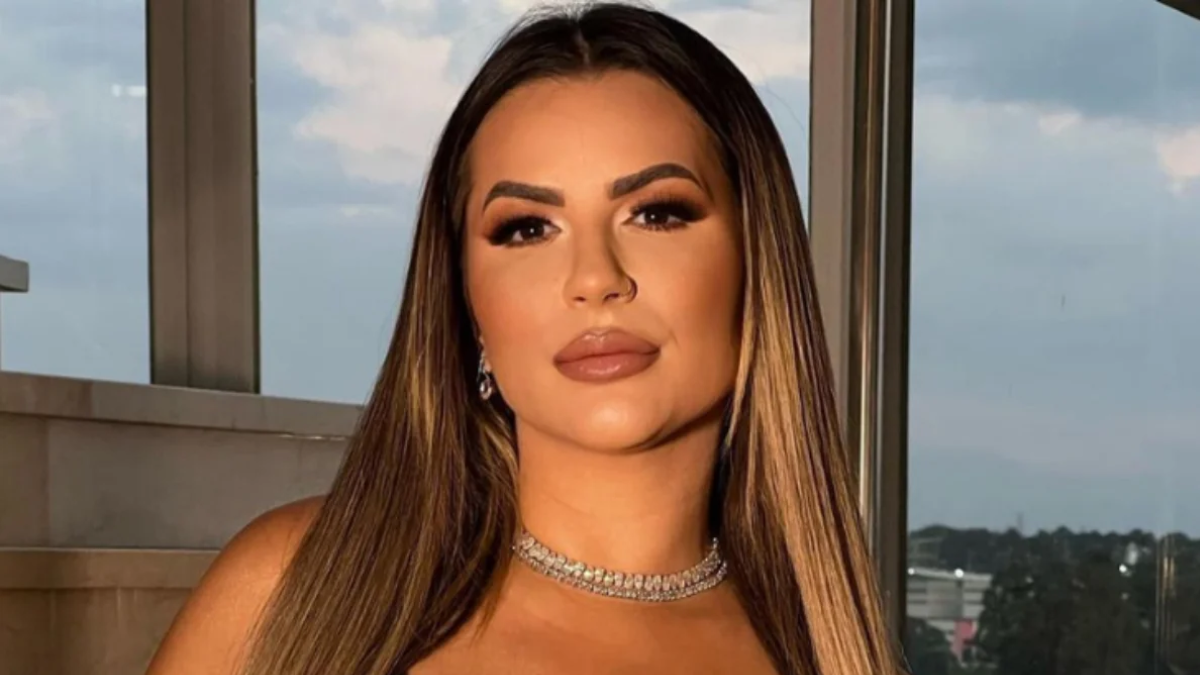 Deolane Bezerra em foto de perfil em ambiente externo, usando colar e maquiagem marcada, após nova negativa de habeas corpus; apoiadores fazem ato por liberdade.