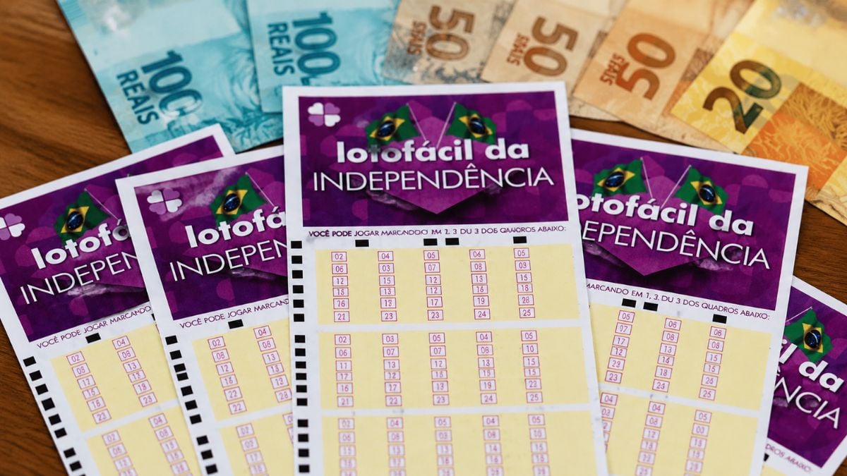 Lotofácil da Independência com cartões de apostas e números visíveis, em meio a outras cartelas de loteria, tema de sorteio com prêmio de R$ 300 milhões.