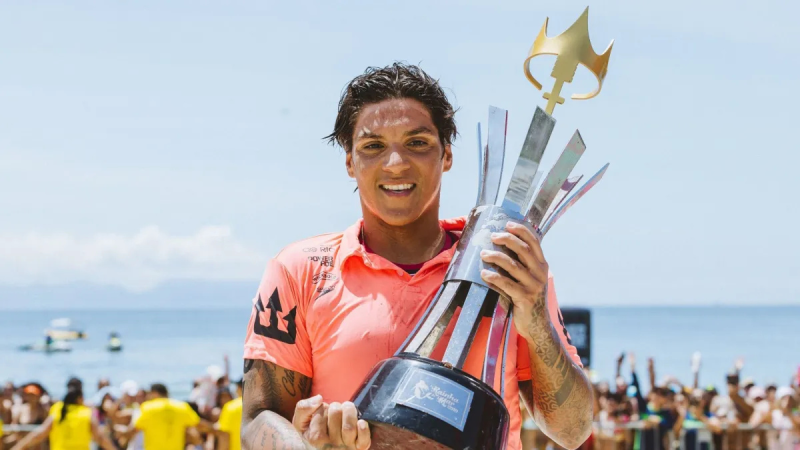 Ana Marcela Cunha completa a travessia do Canal da Mancha, sorrindo com a taça de premiação e comemorando a quebra do recorde sul-americano na praia, diante do mar