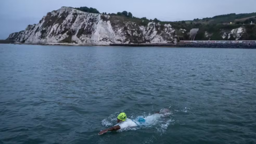 Ana Marcela Cunha atravessando o Canal da Mancha, nadando nas águas frias com o mar agitado ao fundo, durante competição ao ar livre. Foto: Jonne Roriz/COB.