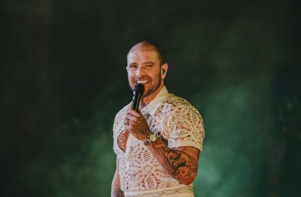 Diogo Nogueira em apresentação ao microfone, em foto de divulgação do evento no Centro de Eventos A Poderosa, com foco na Festa dos Pais em Hortolândia.