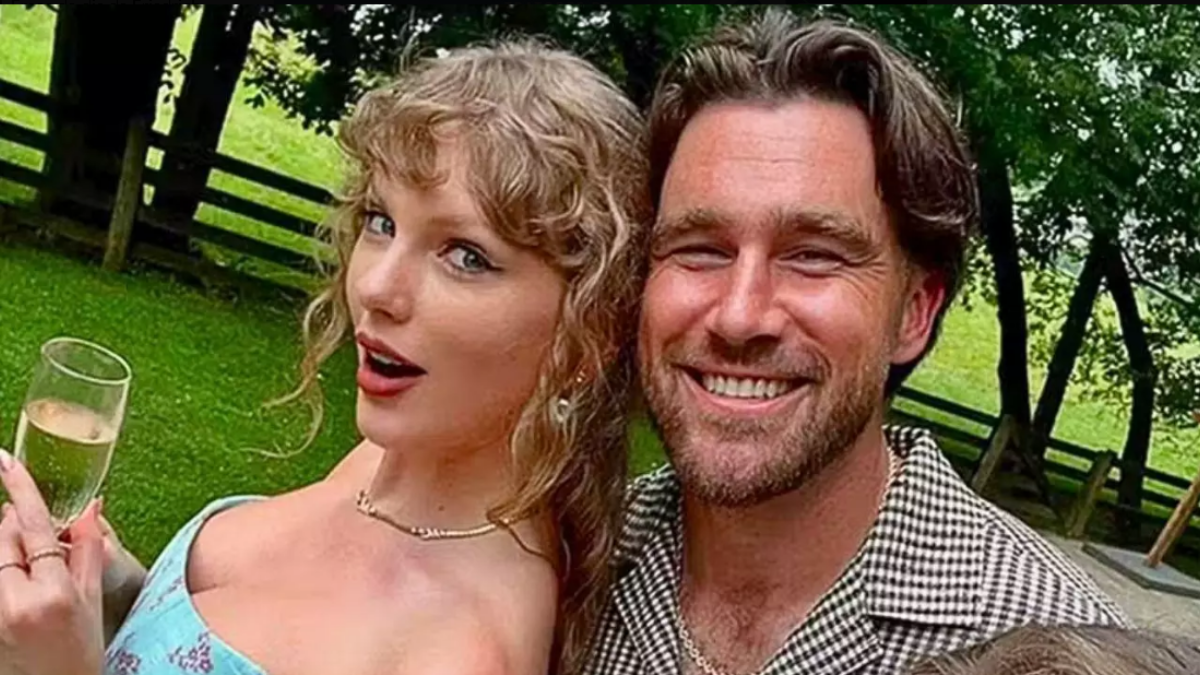 Casamento Taylor Swift: foto de Taylor Swift ao lado de um homem sorridente em um ambiente externo com mesa e bebida em taças, estilo celebração ao ar livre.