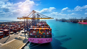 Plano Brasil Soberano 3: Vista aérea de um navio cargueiro no porto, com contêineres coloridos empilhados e ponte/guindaste ao fundo, representando apoio a empresas afetadas por tarifas dos EUA e liberação de recursos do Governo.