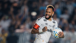 Neymar em partida de futebol, com expressão de irritação e rebate, segurando uma bola na mão enquanto gesticula próximo à linha lateral.