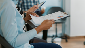Vagas de emprego Piracicaba: Profissionais em reunião de trabalho analisando documentos e formulários em uma mesa, sugerindo candidatura a vagas de emprego na Região de Piracicaba. Região de Piracicaba abre 1,2 mil vagas de emprego; veja como se candidatar.